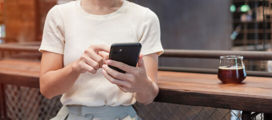 Casual Businesswoman holding and using smartphone for sms messages, young woman typing touchscreen mobile phone in coffee cafe or modern office. lifestyle, technology, Social media and network concept