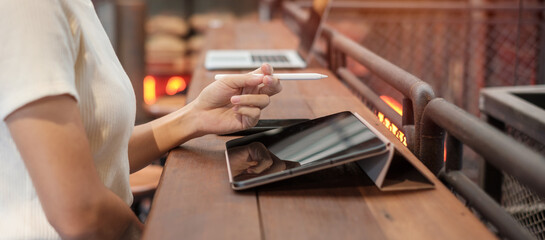 woman using tablet for sms messages, hand holding pencil typing touchscreen mobile phone in cafe or modern office. lifestyle, technology, Social media and network concept