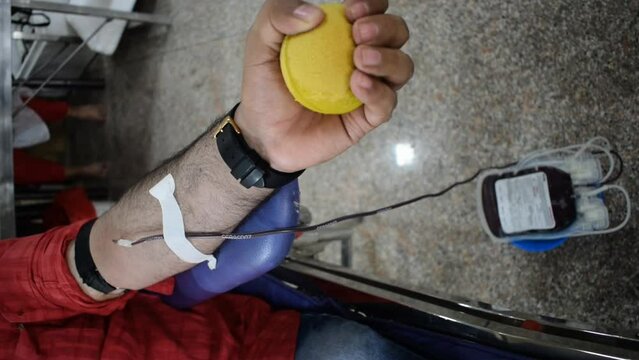 Blood donor at Blood donation camp held with a bouncy ball holding in hand at Balaji Temple, Vivek Vihar, Delhi, India. Also concept image for World blood donor day on June 14 every year