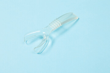 Retractor Dental lip retractor Access to the oral cavity. Wide mouth opening for a dental procedure on a clean blue background