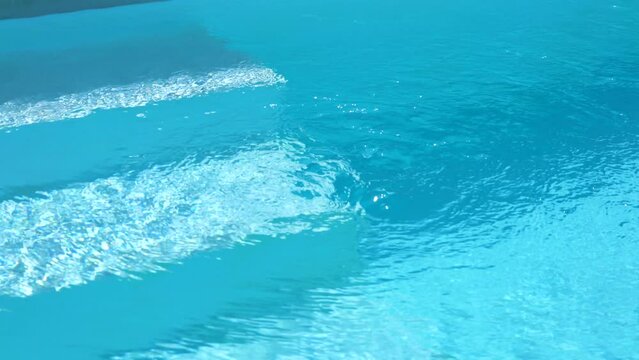 Water flowing out from whirlpool pumping system of cleary blue transparent swimming pool. Seamless loop, 4k footage with steady camera. system of cleary blue transparen