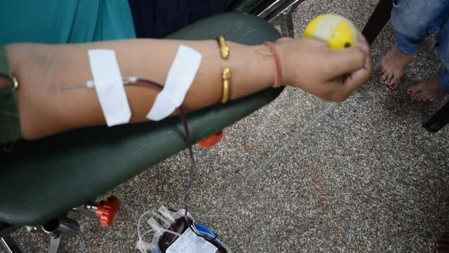 Blood donor at Blood donation camp held with a bouncy ball holding in hand at Balaji Temple, Vivek Vihar, Delhi, India. Also concept image for World blood donor day on June 14 every year