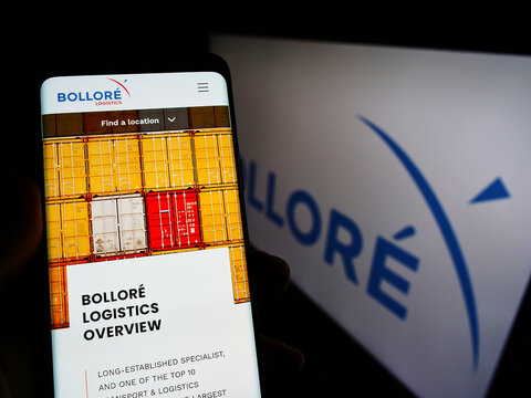 Stuttgart, Germany - 02-06-2022: Person holding cellphone with wesbite of French conglomerate company Bollore SE on screen in front of logo. Focus on center of phone display.