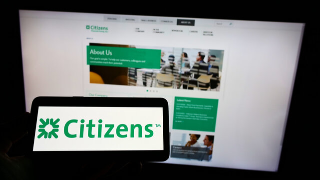 Stuttgart, Germany - 02-06-2022: Person holding smartphone with logo of US banking company Citizens Financial Group Inc. on screen in front of website. Focus on phone display.