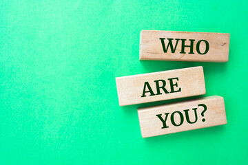 Who are you question words on wooden blocks on green background.