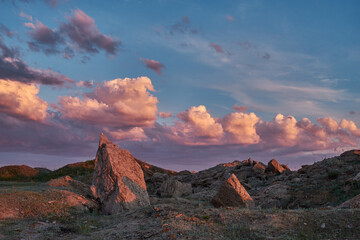 large boulders against the sunset sky with clouds