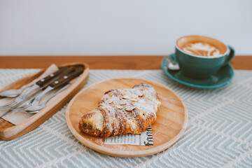 Croissants with nuts flakes crumbs and coffee on the table in the cafe, Delicious breakfast morning, Cafe tone color, Selective focus.