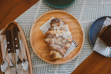 Croissants with nuts flakes crumbs and coffee on the table in the cafe, Delicious breakfast morning, Cafe tone color, Selective focus.