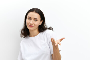 a sweet, pleasant, beautiful woman stands on a white background in white flour and looking at the camera holds her hand in a relaxed gesture. Horizontal photo with an empty space