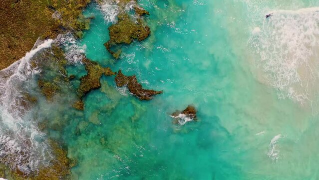 A surfer with beautiful turquoise water, waves, and coral reefs in Perth, Western Australia	