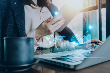 businesswoman hand working with laptop computer, tablet and smart phone in modern office with virtual icon diagram at modernoffice in morning light