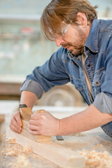 Craftsman planed wood in a workshop