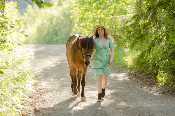 Icelandic horse on gravel road with young woman. Shot in the evening middle of the summersummer in Finland