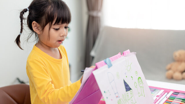 Asian Little kid girl drawing at home creativity development.
