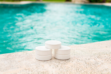 Chlorine tablets on the edge of a swimming pool, Closeup of chlorine tablets for swimming pool...