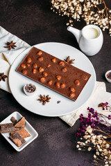 Coffee in a white cup with chocolate with hazelnut flowers milkweed with milk on a black background