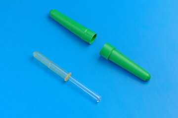 Medical pipette with a case on a blue background close-up