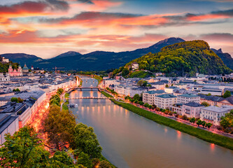 Naklejka premium Aerial summer cityscape of Salzburg, Old City, birthplace of famed composer Mozart. Picturesque sunset in Eastern Alps, Austria, Europe. Stunning evening landscape with Salzach river.