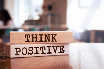 Wooden blocks with words 'think positive'.