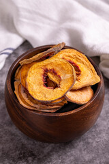 Dried peach slices. Sliced dried peaches on a dark background. Sun-dried fruit. Close-up.