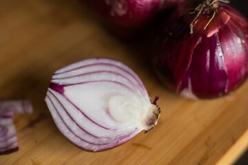 close up of cut red onion in wooden board