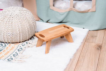 Children's wooden chair stands on a white mat in the children's room loft style