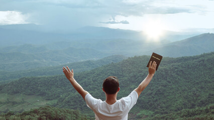man praying to god and  raise their arms thank God on the mountain