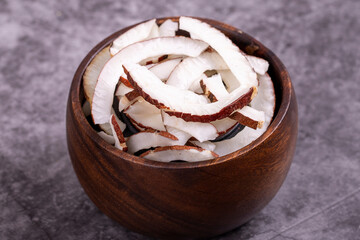 Dried coconut slices. Sliced dry coconut on dark background. Sun-dried fruit. close up