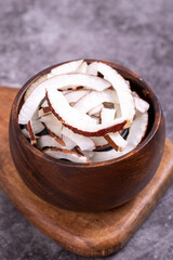 Dried coconut slices. Sliced dry coconut on dark background. Sun-dried fruit. close up