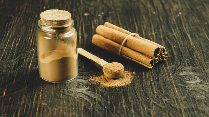 Fototapeta na wymiar cinnamon ground sticks ceremony cocoa cloves ground coffee spices on wooden table closeup