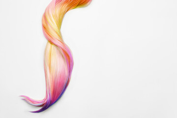 Fototapeta na wymiar Strand of beautiful multicolored hair on white background, top view