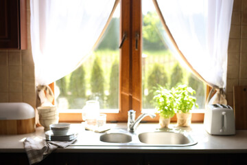 Blurred view of stylish kitchen interior with sink near window