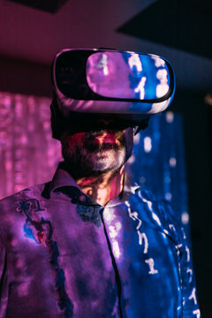 Digital code falling on mature man wearing virtual reality simulator