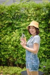 An Asian woman gardener portrait with a pruner.