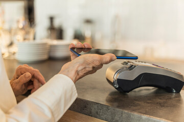 Senior woman making payment through mobile phone
