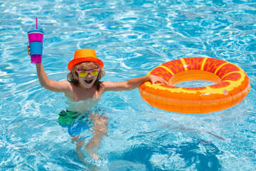 Little child boy in swimming pool with inflatable toy ring. Kids swim on summer vacation. Swim for child on float. Beach sea and water fun. Summer kids cocktail.