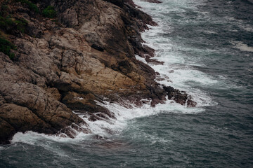 Obraz premium The scenery of the wave on the rocky bay.