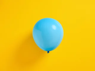 Foto op Plexiglas Blauwe opgeblazen ballon op gele achtergrond. © Cagkan