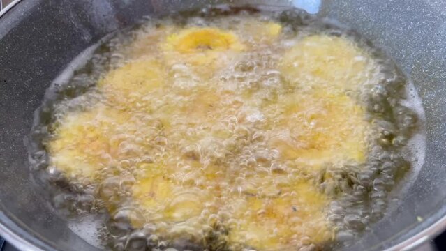 Yellow plantains (patacones) in the frying pan - stock video