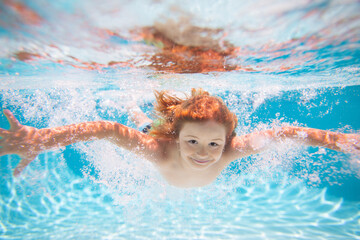 Underwater boy in the swimming pool. Cute kid boy swimming in pool under water. Summer kids in water in pool underwater.