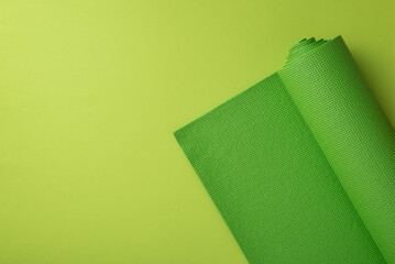 Sports accessories concept. Top view photo of green yoga mat on isolated green background with...