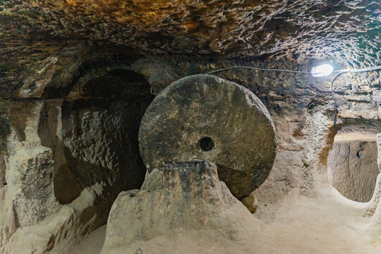 A round stone door in a cave. Cave of the 17th century Orthodox hermits. A narrow passage.