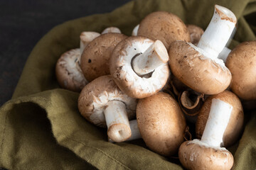 Group of Portobello mushrooms on green napkin.