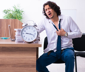 Young male employee unhappy with excessive work