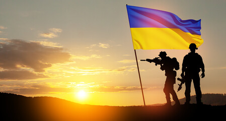 Flag of Ukraine with silhouette of soldiers against the sunrise or sunset. Concept - armed forces of Ukraine. Relationship between Ukraine and Russia.