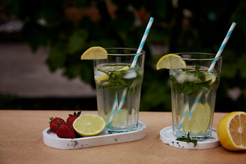 Colorful infused water with lemon, lime, mint and strawberries. Healthy natural summer cocktails. Refreshing, diet, detox, natural, fortified water. Hard zeltzer, nootropics. Summertime beverages.