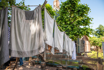 Enkhuizen, Netherlands. June 2022. Talking fishermen men and women and the backdrop of drying laundry.