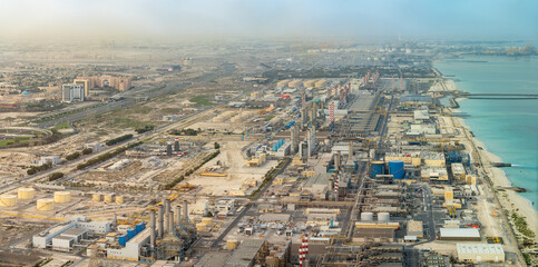 Dubai, Industriegebiet an der Küste beim Sonnenaufgang mit Sandsturm