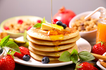 stack of pancakes with syrup and fruits