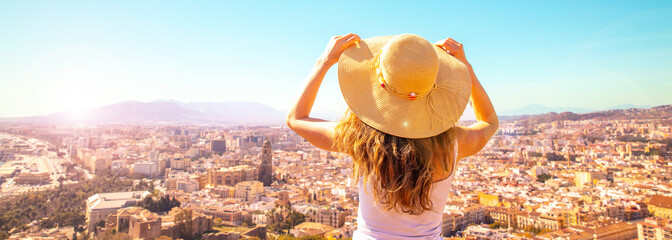 woman with hat enjoys the panoramic city landscape view of Malaga- Andalusia in Spain